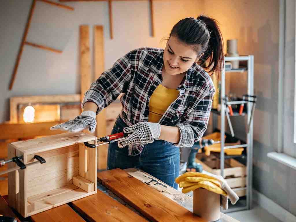 a woman working on a wood box