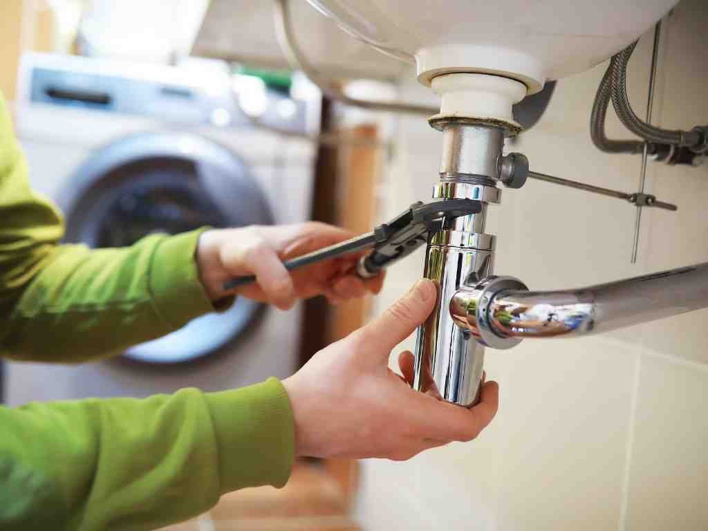 a person fixing a sink